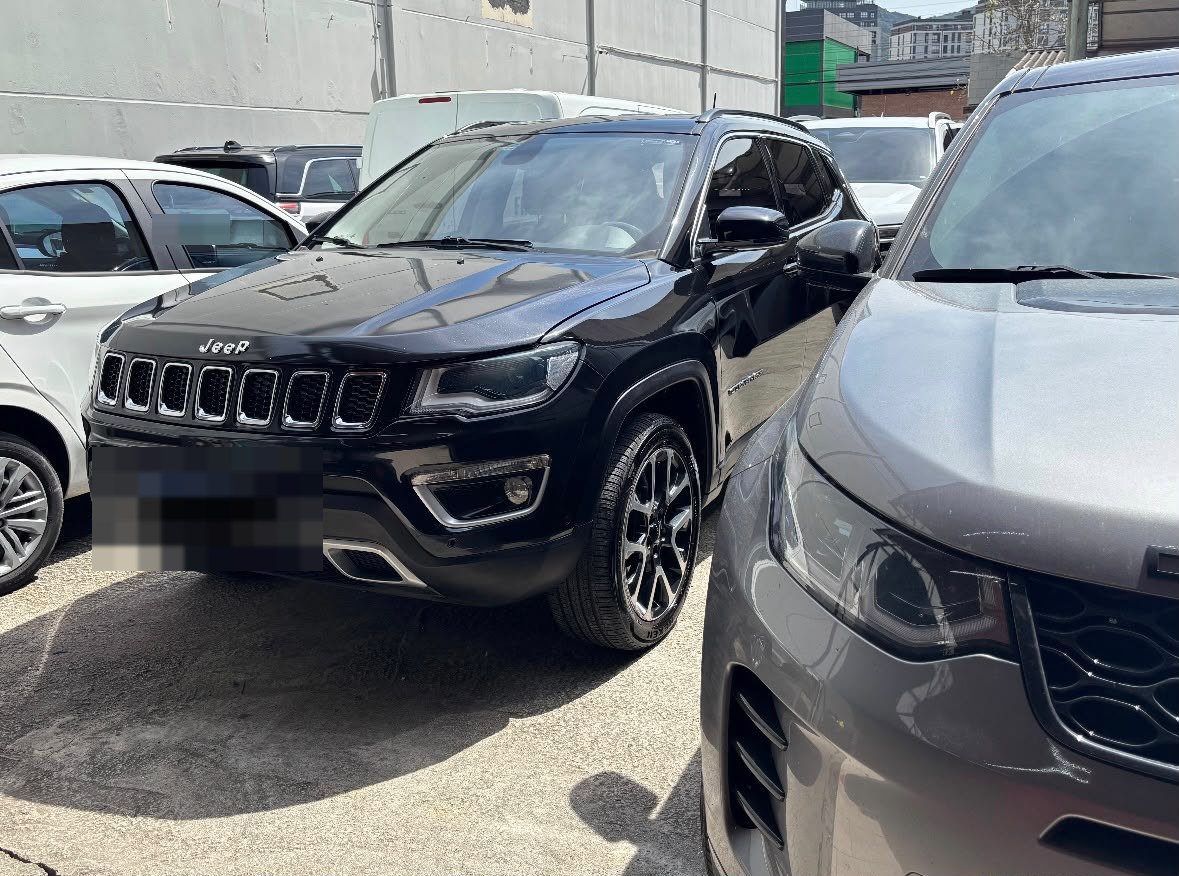 SUV preta estacionada em frente à oficina com a pintura espelhada