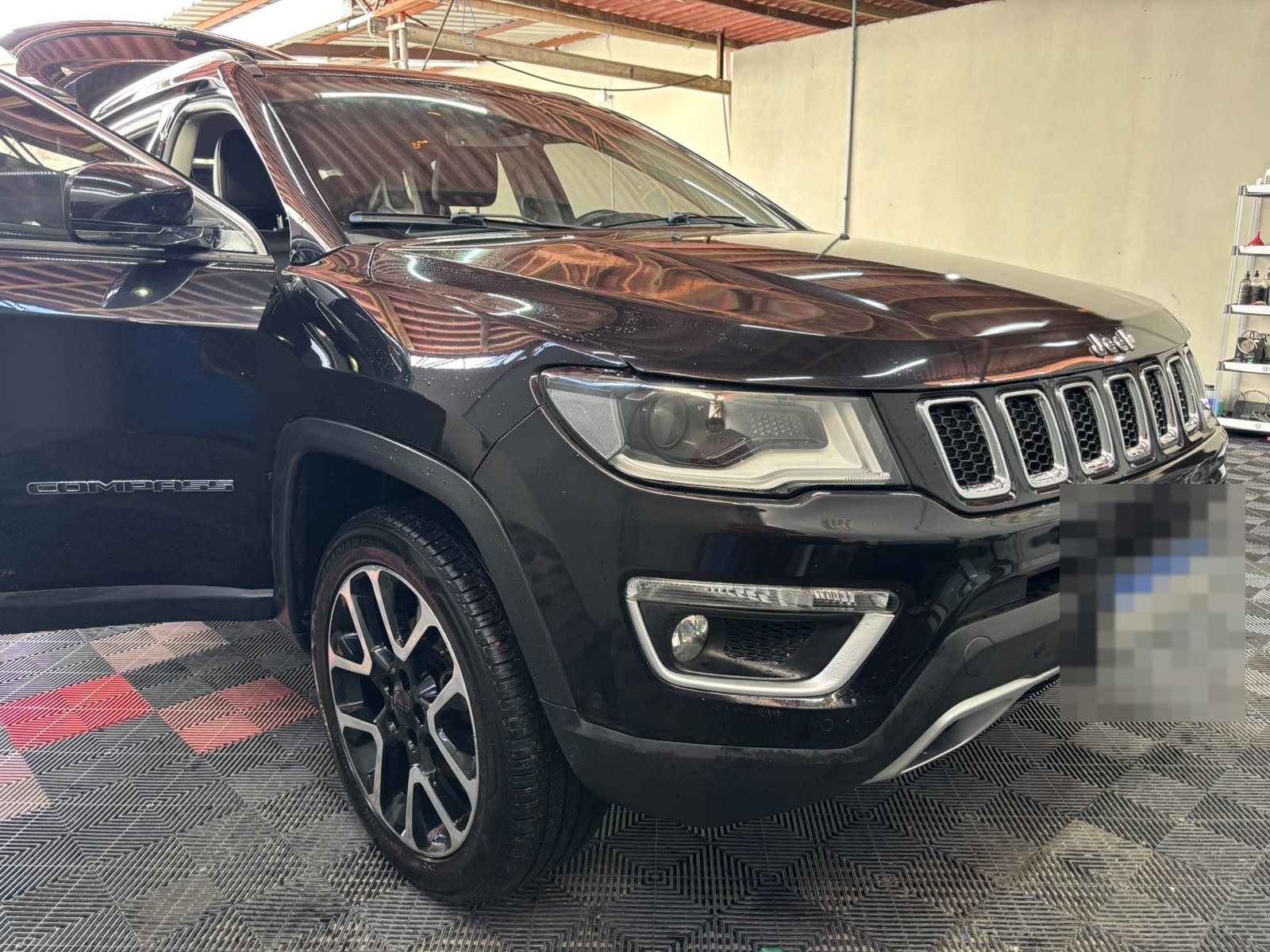 SUV preta com a pintura polida no box de detalhamento